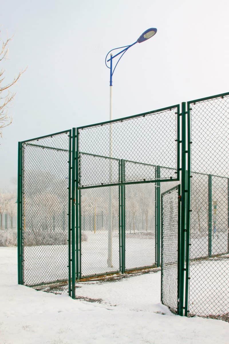 Tennis court fence in the snow, closeup of photo

