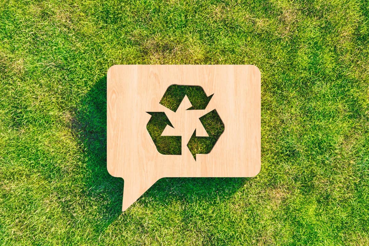 recycling symbol carved in wood on grass. recycling concept