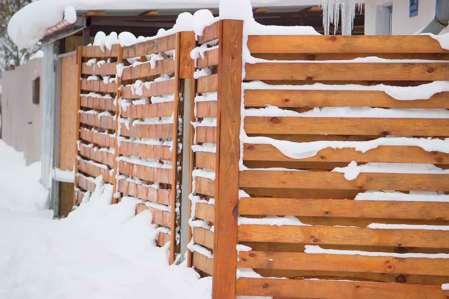 wooden fence in the snow at white background

