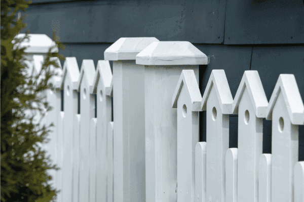 A white wooden fence with two gate posts in the center.