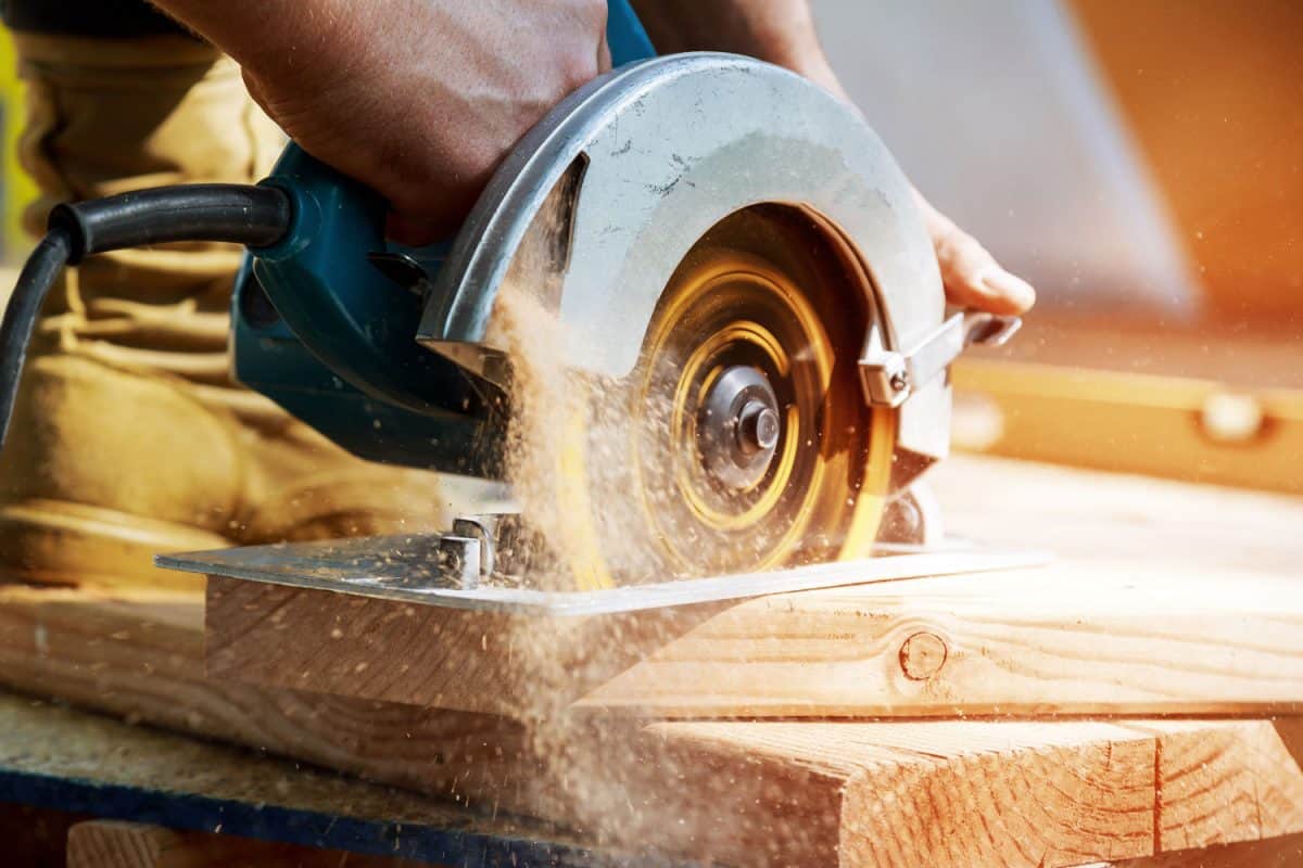 Carpenter cutting a piece of wood using a plunge saw