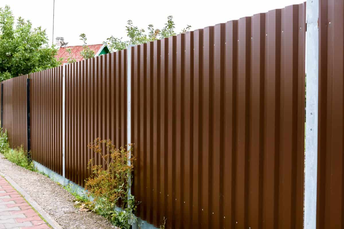 Close-up of a brown metal profile fence. Corrugated surface.
