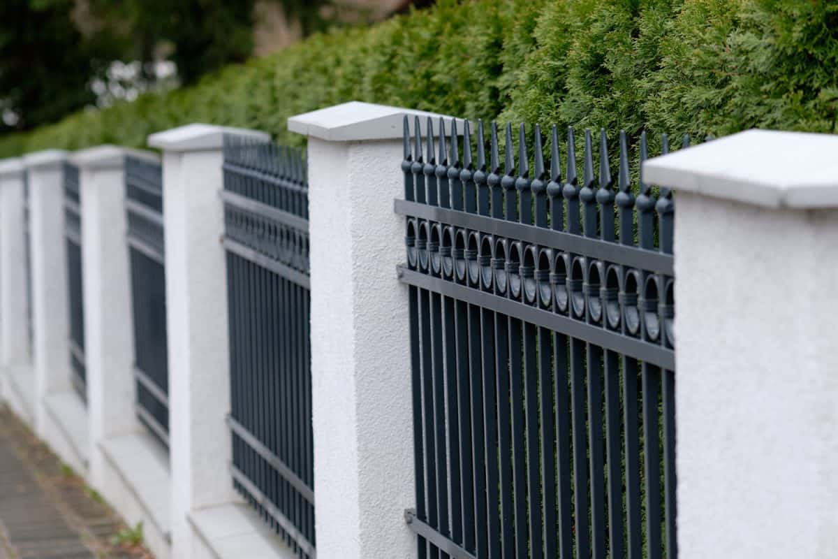 Elegant grey iron fence with white pillars