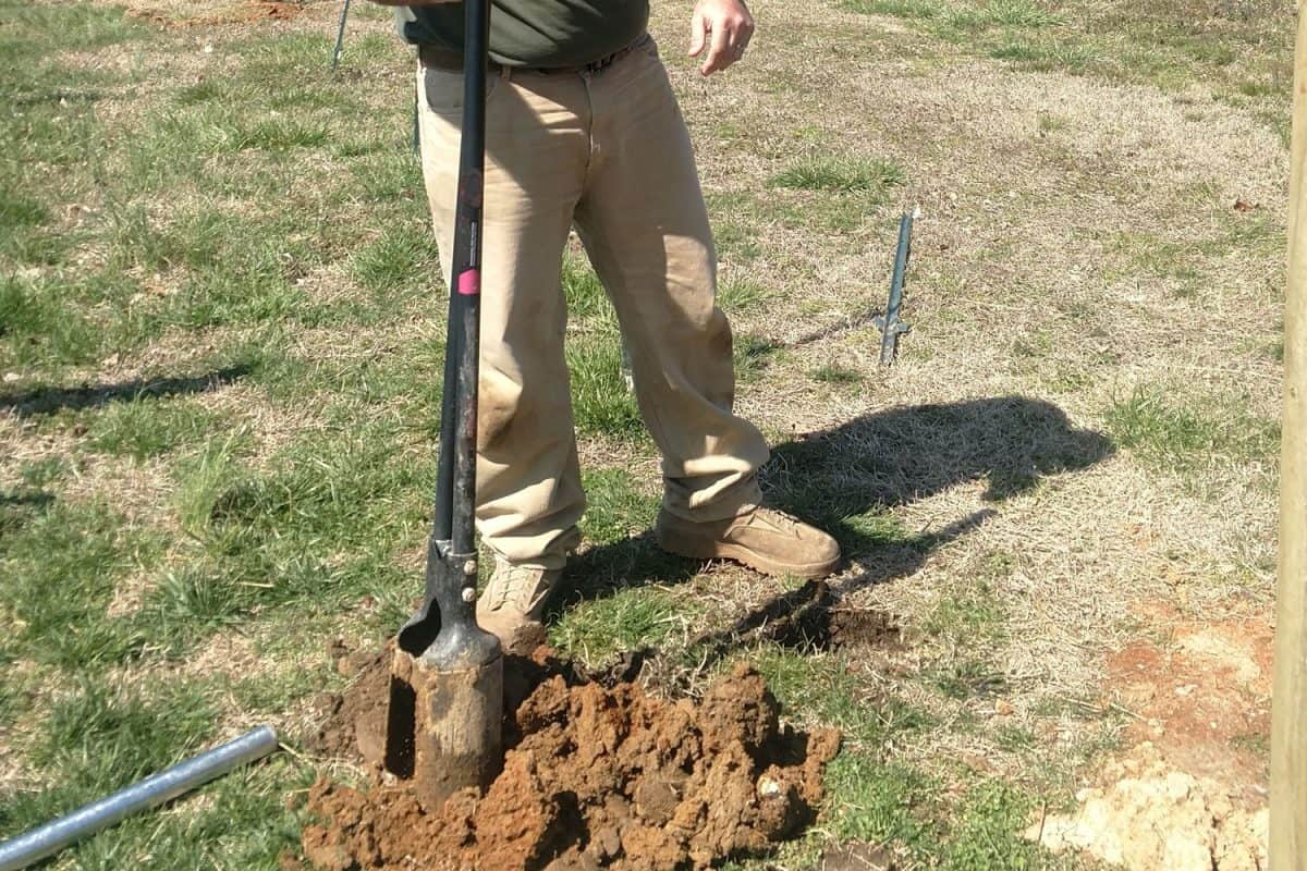 Man digging a hole for his fence post