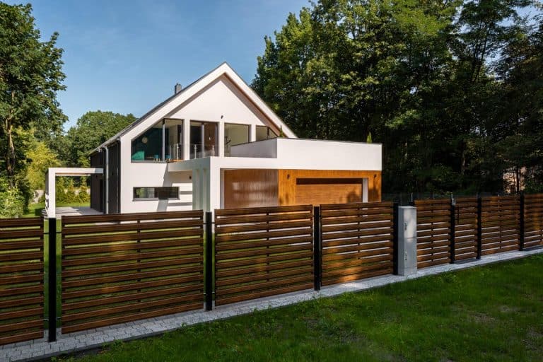 Spacious white house with wooden decoration on garage and wood style fence, Should Your Fence Match Your House?
