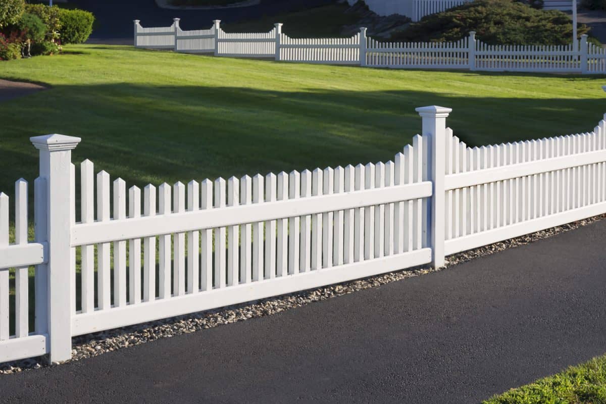 White picket fence that delineates the grass from the pathway

