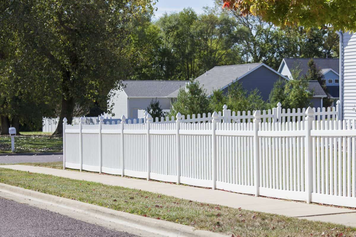 White vinyl picket fence surrounding a yard

