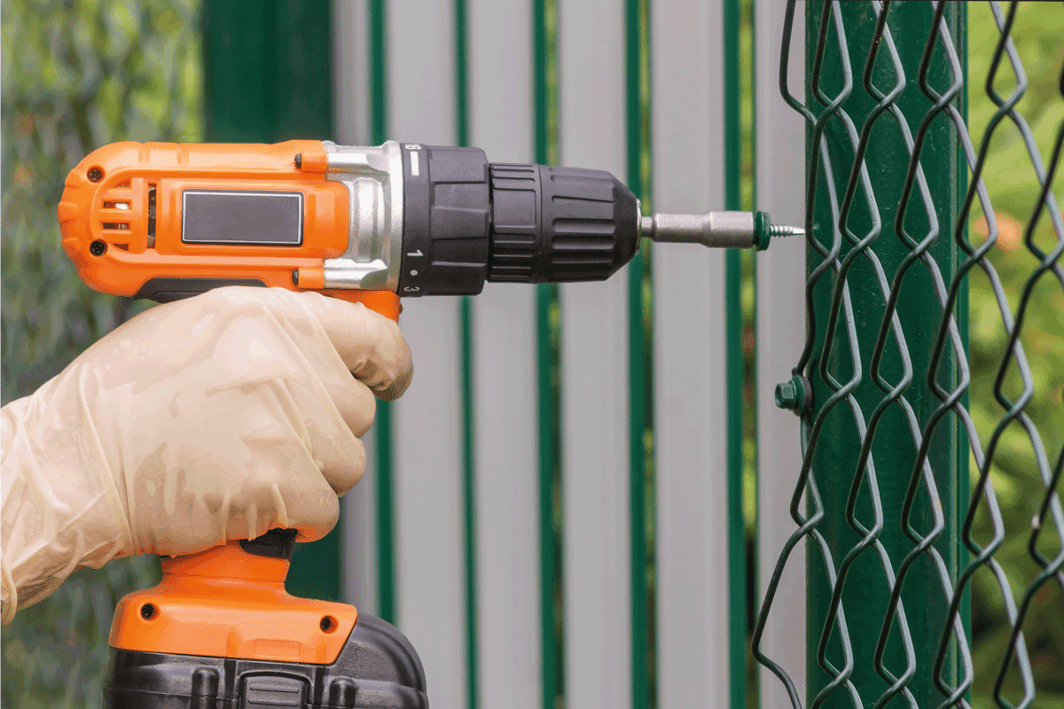 Work with an electric drill to strengthen the netting of the chain-link on a metal fence. How Long Do Chain Link Fences Last
