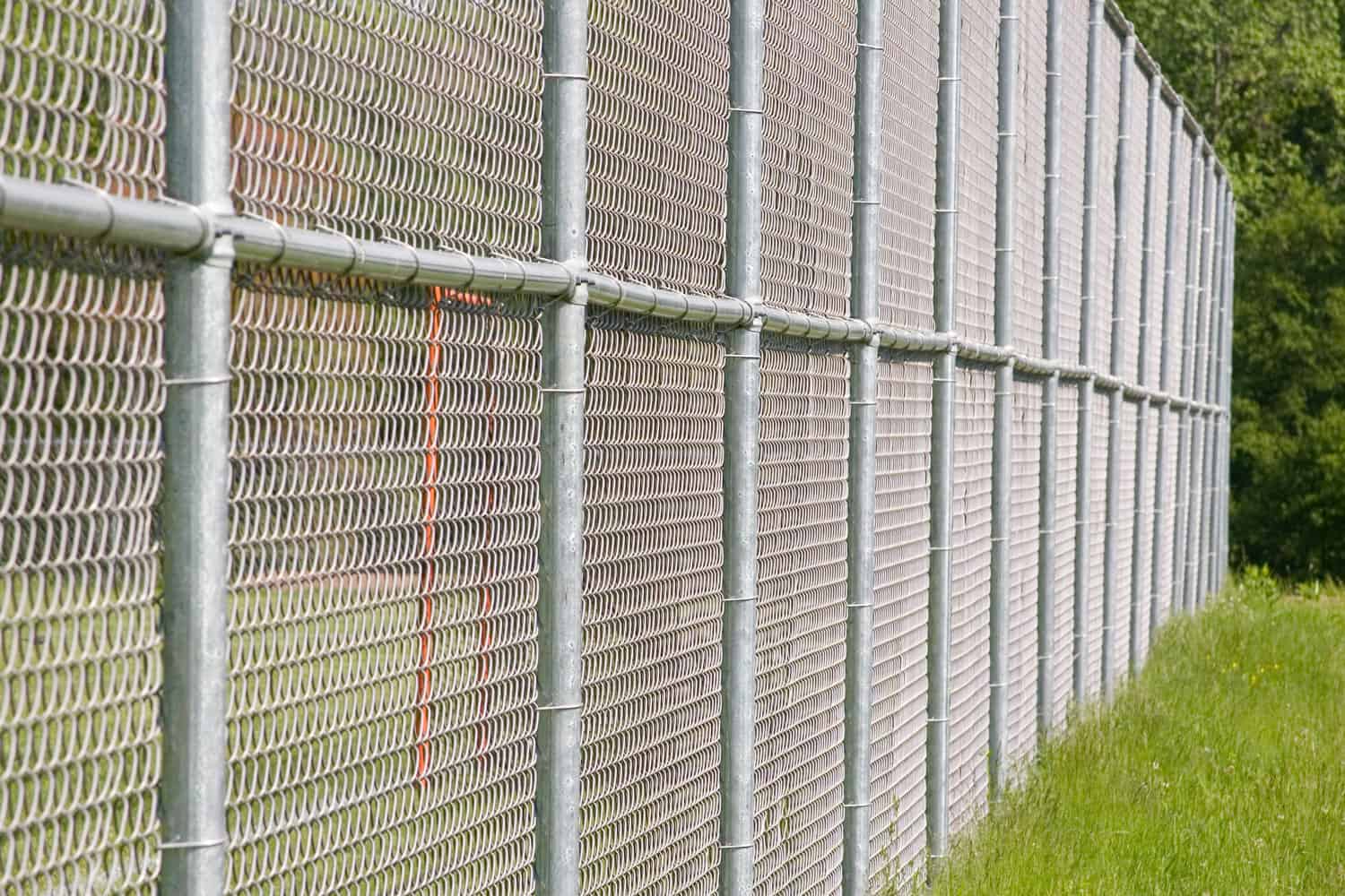 a tall chain link fence borders a playing field