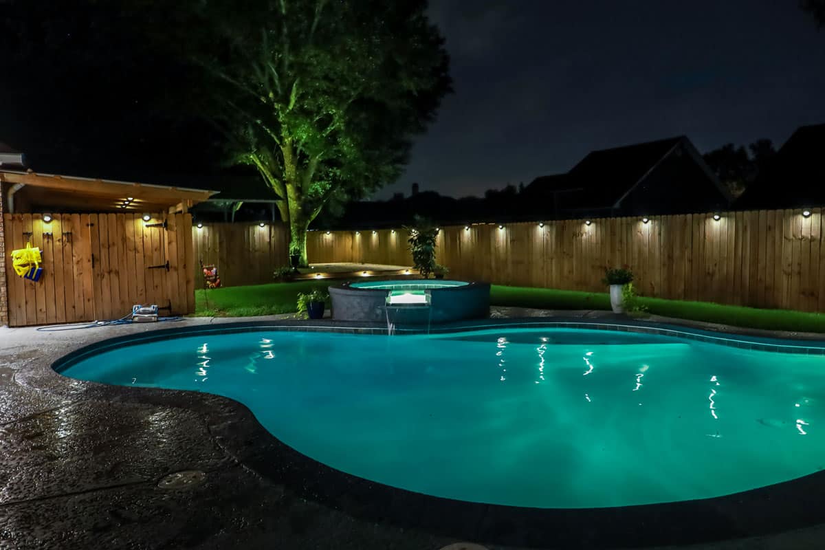 swimming pool and Hot Tub hot tob at night with solar lights around the fence for privacy and illumination