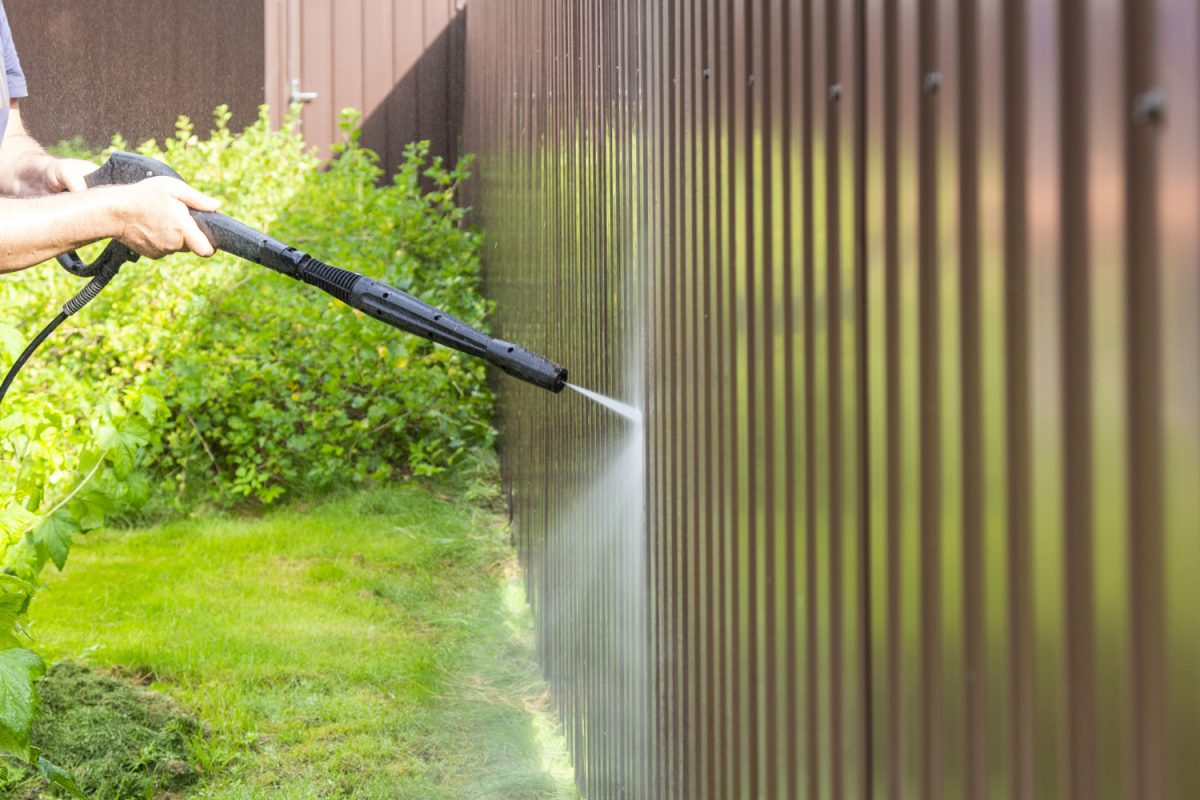 Cleaning fence with high pressure power washer, cleaning dirty wall.

