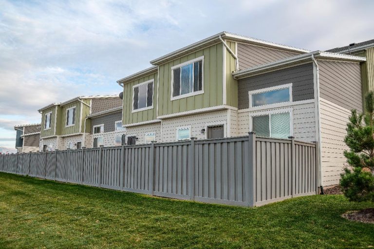 A gray vinyl fence on a residential area, How To Choose Vinyl Fence Color [7 Image Examples Of Available Colors!]