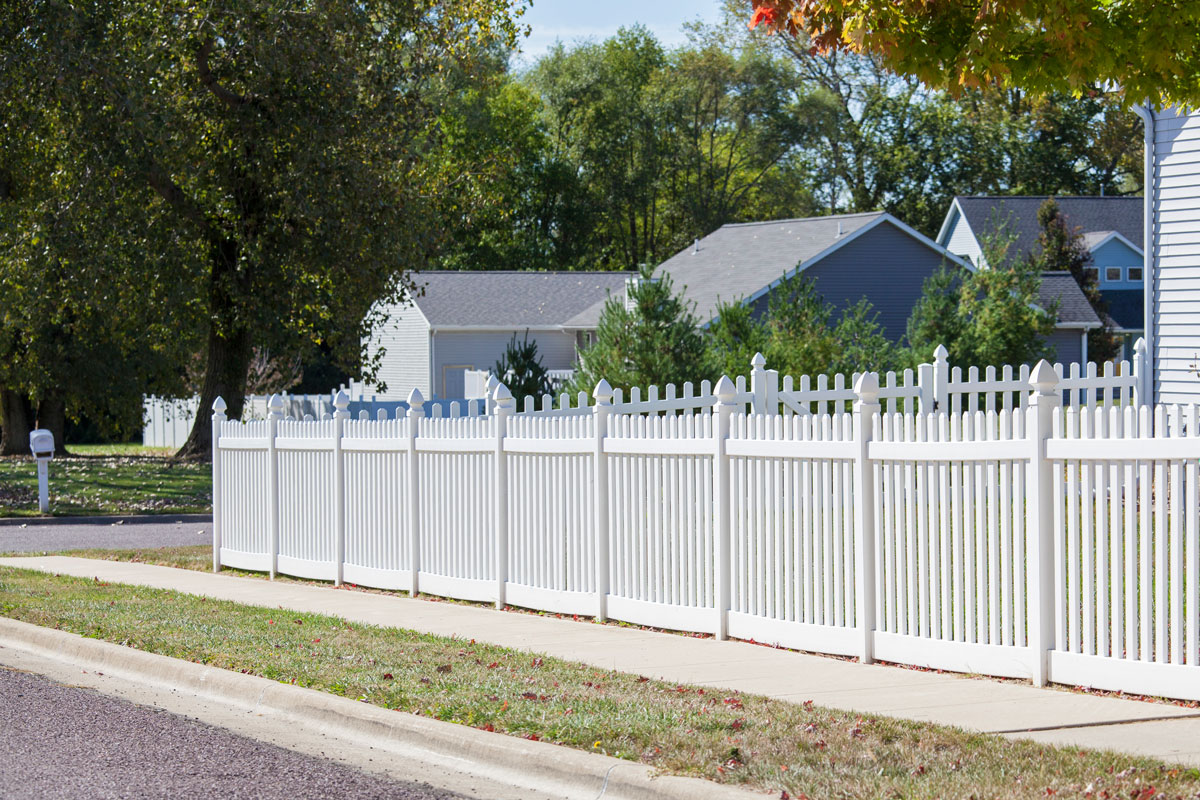 White picket vinyl fence surround a classic American suburban home
