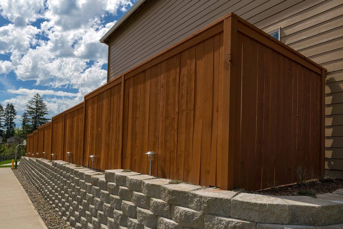 Wood fence cement stack stone blocks retaining wall and landscaping lighting